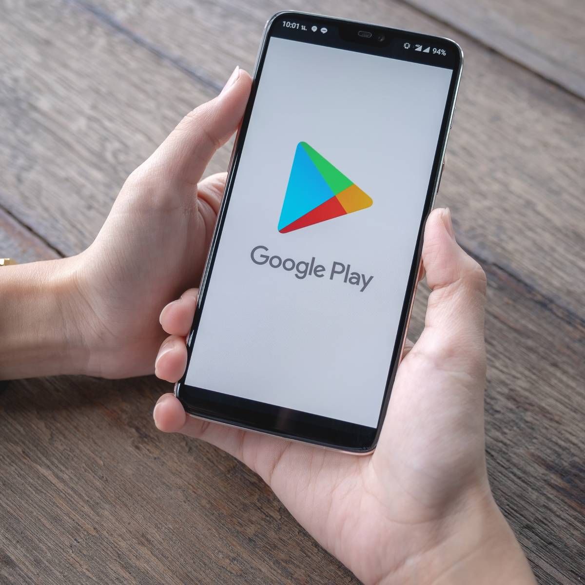 Someone is holding an Android device that is open on the Google Play Store screen.