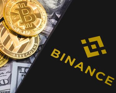 bills, cryptocurrency gold coins, and cellphone on top with Binance on the screen