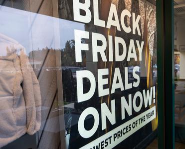 Black Friday Deals advertisement is shown on the storefront of a Columbia Sportswear Factory. Online shopping for Black Friday deals can have more potential risks. 