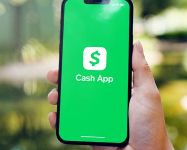 Holding cellphone with green Cash App on the screen