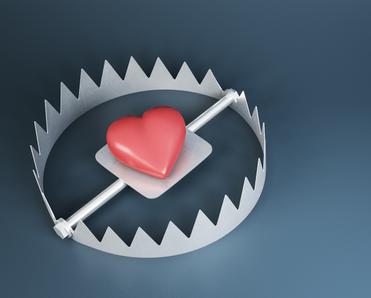 A red heart sits in the middle of a steel bear trap to signify catfishing and other romance scams