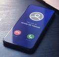 Cellphone screen incoming call with caller id saying SCAM OF FRAUD 