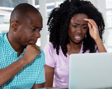 Concerned couple looking at laptop