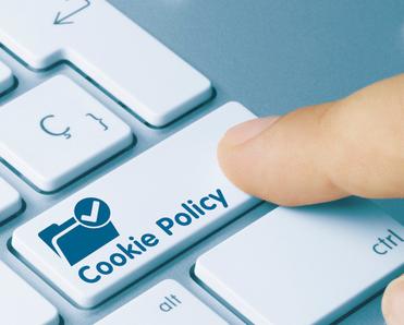 A finger shown pressing a button on a keyboard that says &quot;Cookie Policy.&quot;
