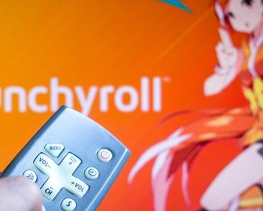 TV screen with orange background Crunchyroll streaming anime character with hand holding remote to play 
