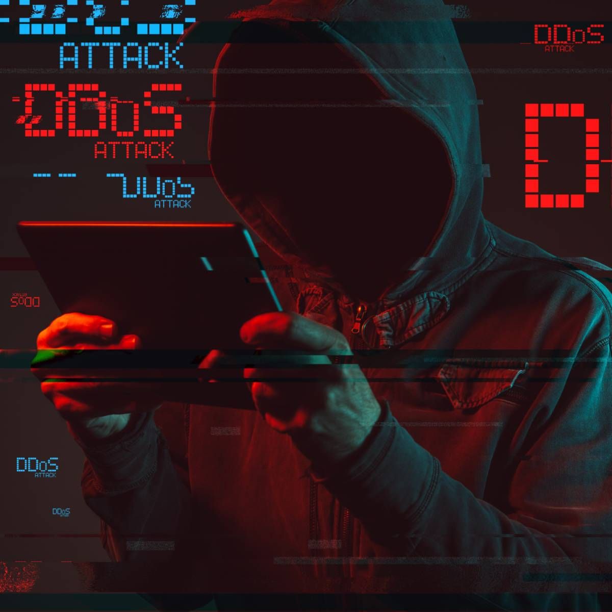 A hooded hacker uses a tablet to 