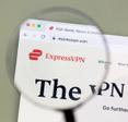 A magnifying glass zooms in on the ExpressVPN logo and homepage. ExpressVPN is one of the more expensive VPN subscriptions but offers reliability and secure features in exchange.