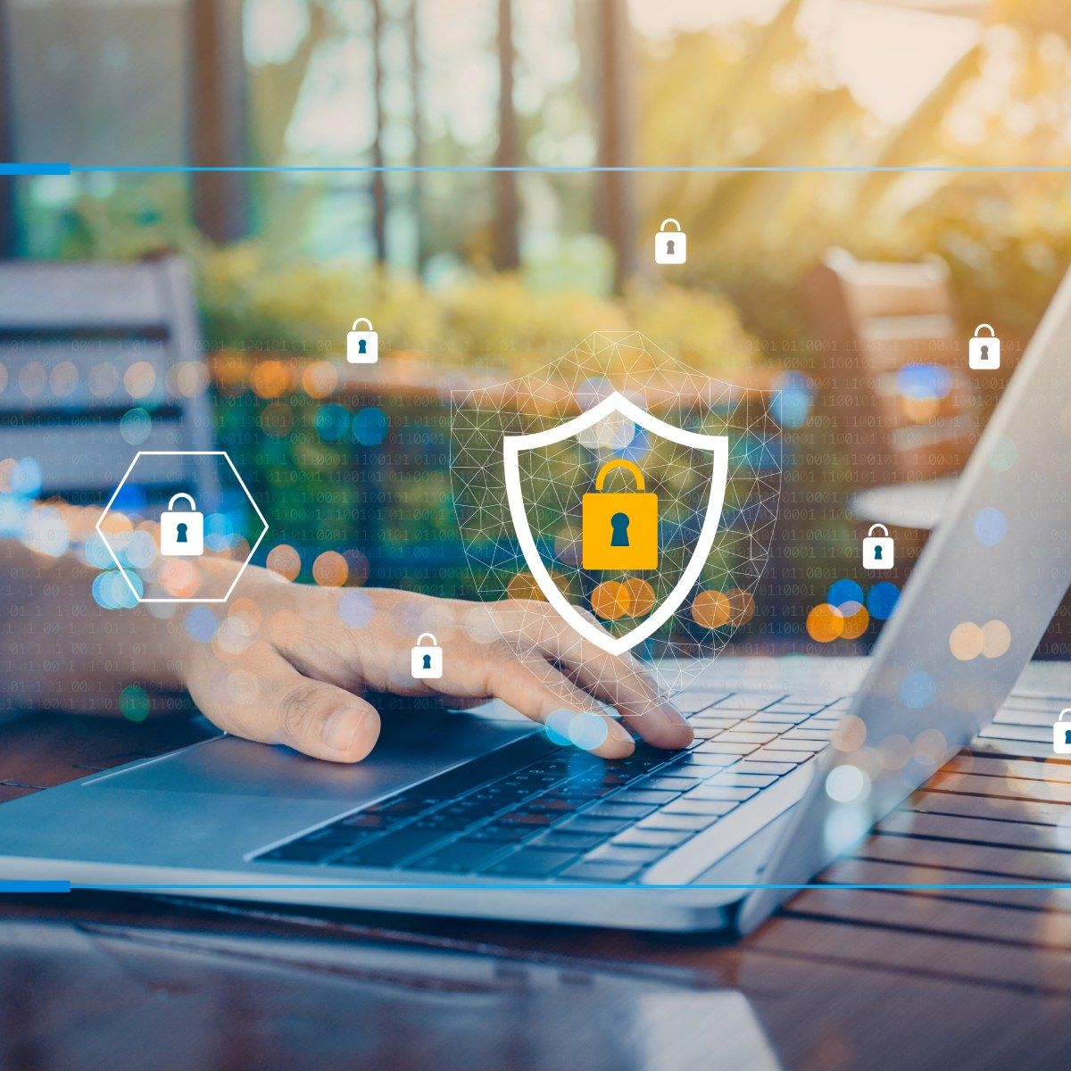 A man&#x27;s hand rests on a laptop keyboard while he sits in an outdoor cafe, lock and shield symbols float in the air