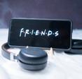 Cellphone with FRIENDS tv show logo on screen and headphones 