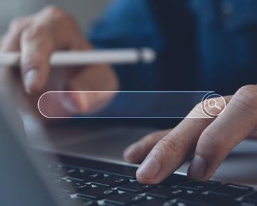 A close-up of a man&#x27;s fingers typing on a Mac laptop keyboard with an illustration of a web browser search bar