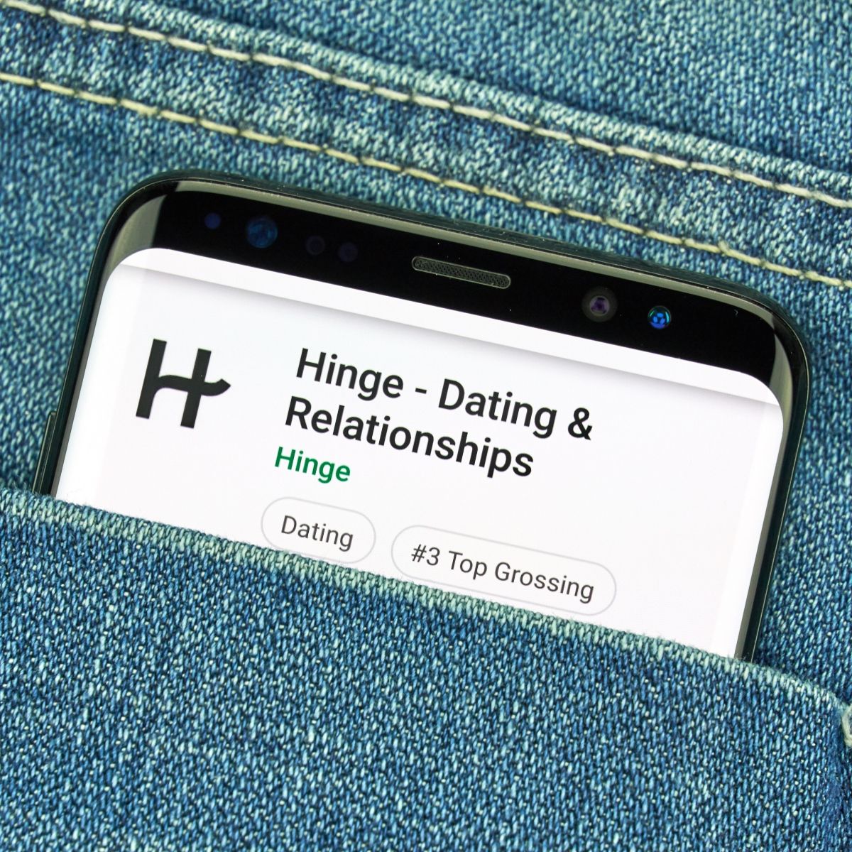 Phone in jeans pocket with dating app Hinge on the screen