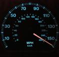 A close-up shot of a lit-up speedometer on a car&#x27;s dashboard. The needle is sitting at just over 150 miles per hour to show fast speeds.