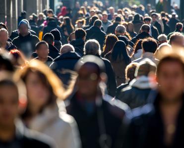 A front-facing photo of a mass of people walking to and fro on a crowded street used to illustrate the concept of browsing the internet anonymously.