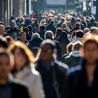 A front-facing photo of a mass of people walking to and fro on a crowded street used to illustrate the concept of browsing the internet anonymously.