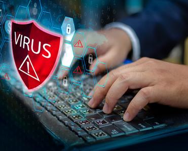 A man&#x27;s hands rest on a laptop keyboard with a red shield and the word &quot;Virus&quot; floating above it to signify the WebHelper virus.