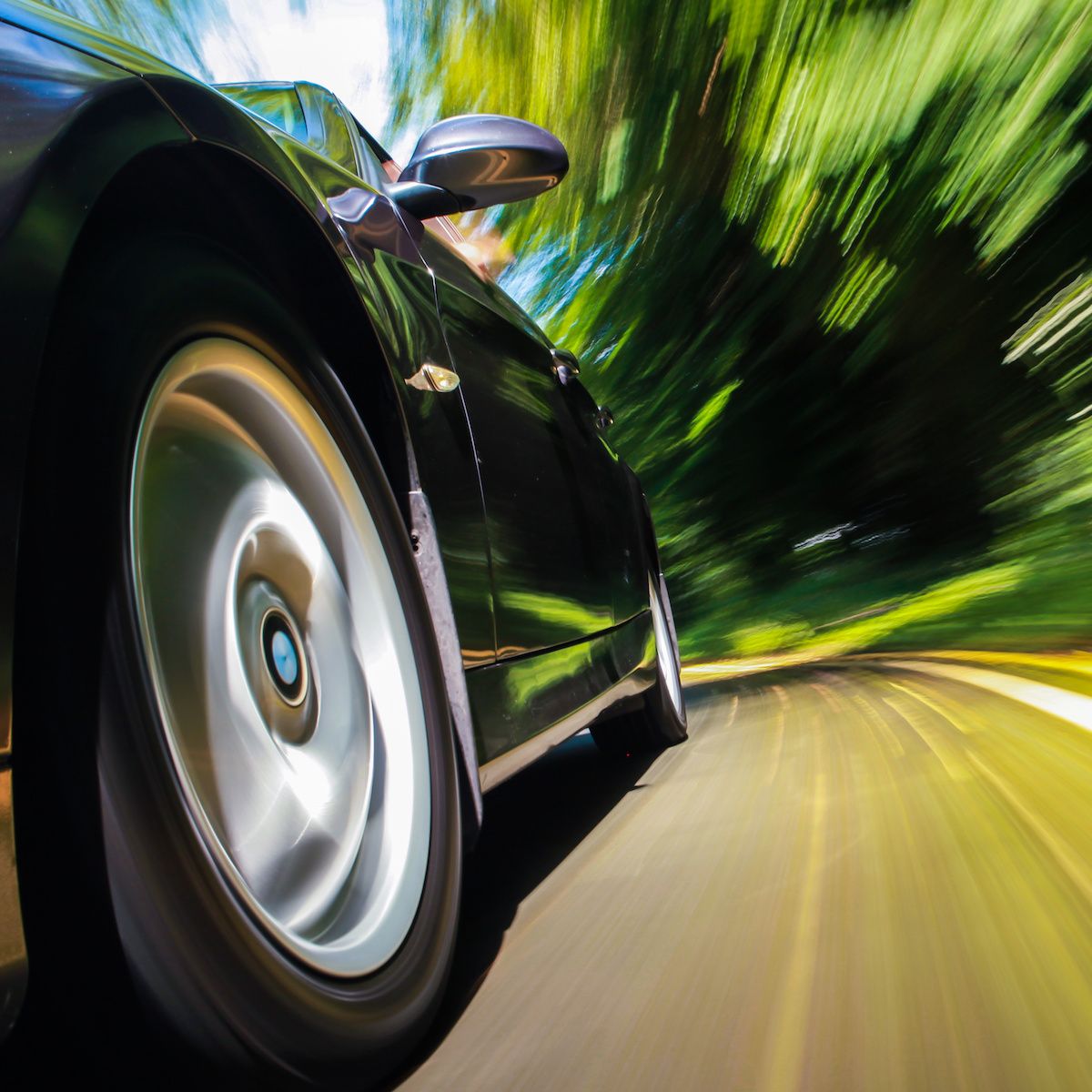 A close-up of the front of a black sports car as it speeds past, signifying increased internet speeds.