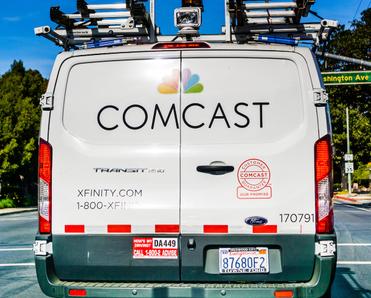 A Comcast Xfinity van drives along a street in the U.S. Switching internet providers could be a hassle, but with the right info, you could find a sweet deal.