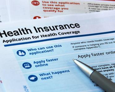 A health insurance application and a pen.