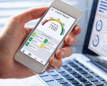 A person holding a smartphone and viewing their credit report with score rating app.