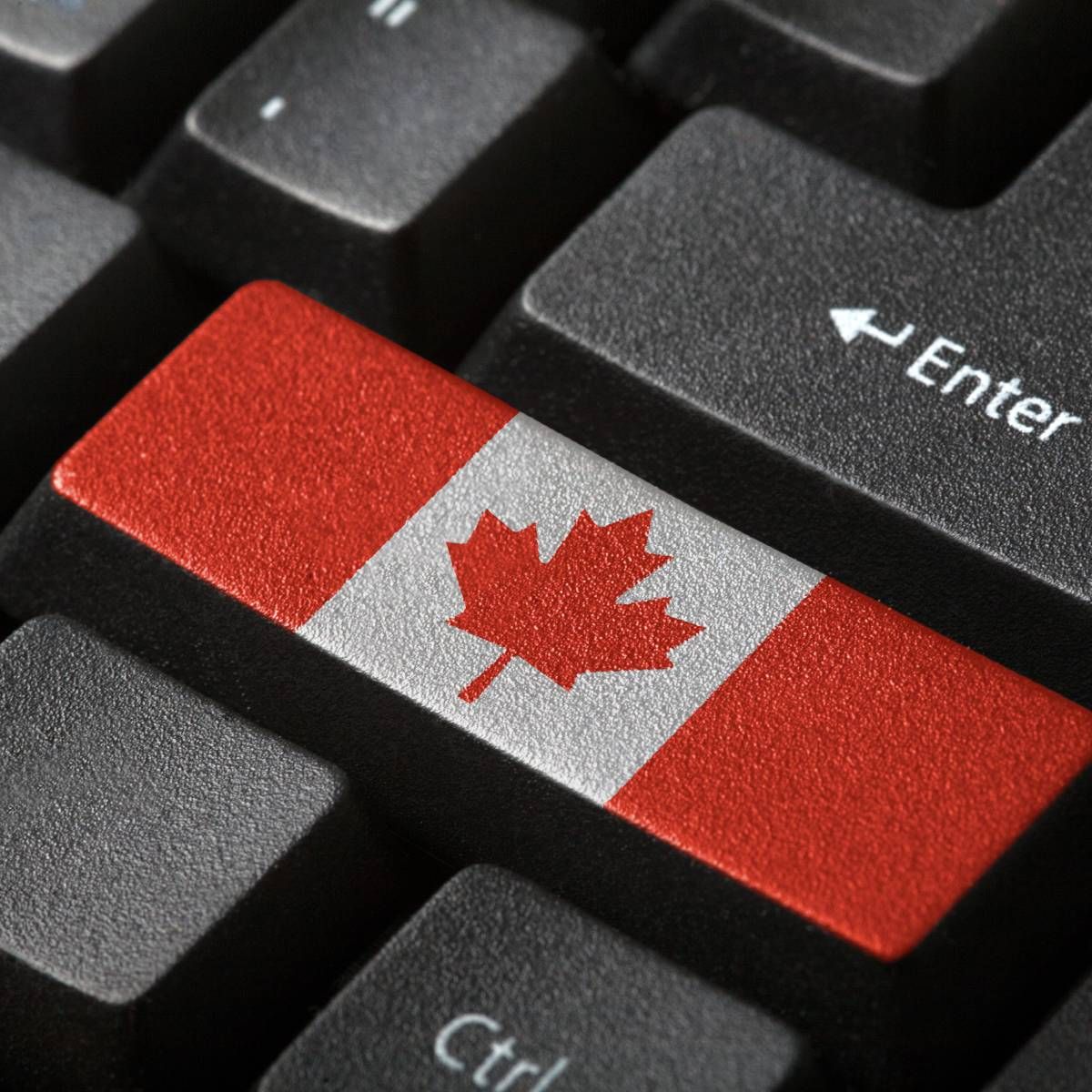 A computer keyboard with a button that has the Canadian flag.