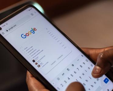 A person is using their smartphone to conduct a Google search.