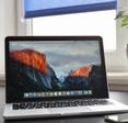 Macbook Pro with retina display on a table along with a smartphone.