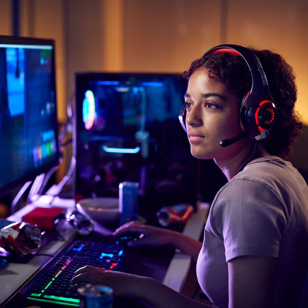 A young woman is playing a video game on her desktop computer.