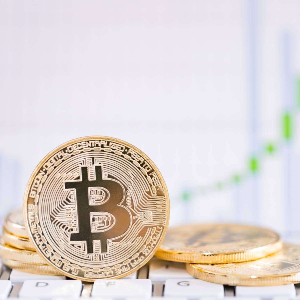 Pile of bitcoins with image of stocks in the background