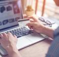 A man types his credit card information into an online shopping site