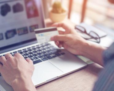 A man types his credit card information into an online shopping site