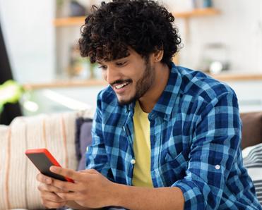 Man sitting on couch and looking at smartphone