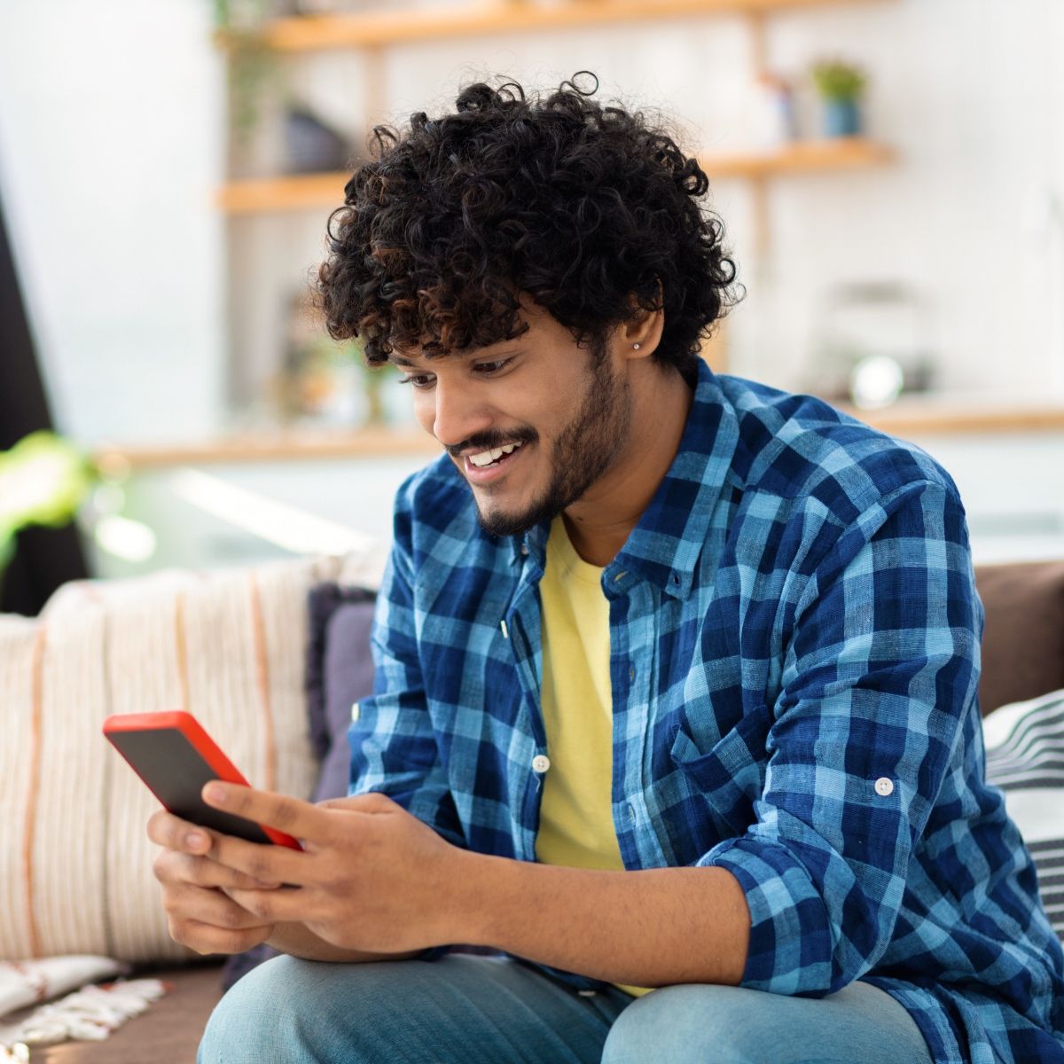 Man sitting on couch and looking at smartphone