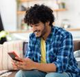 Man sitting on couch and looking at smartphone