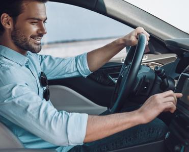 Man driving car pressing screen on the car panel