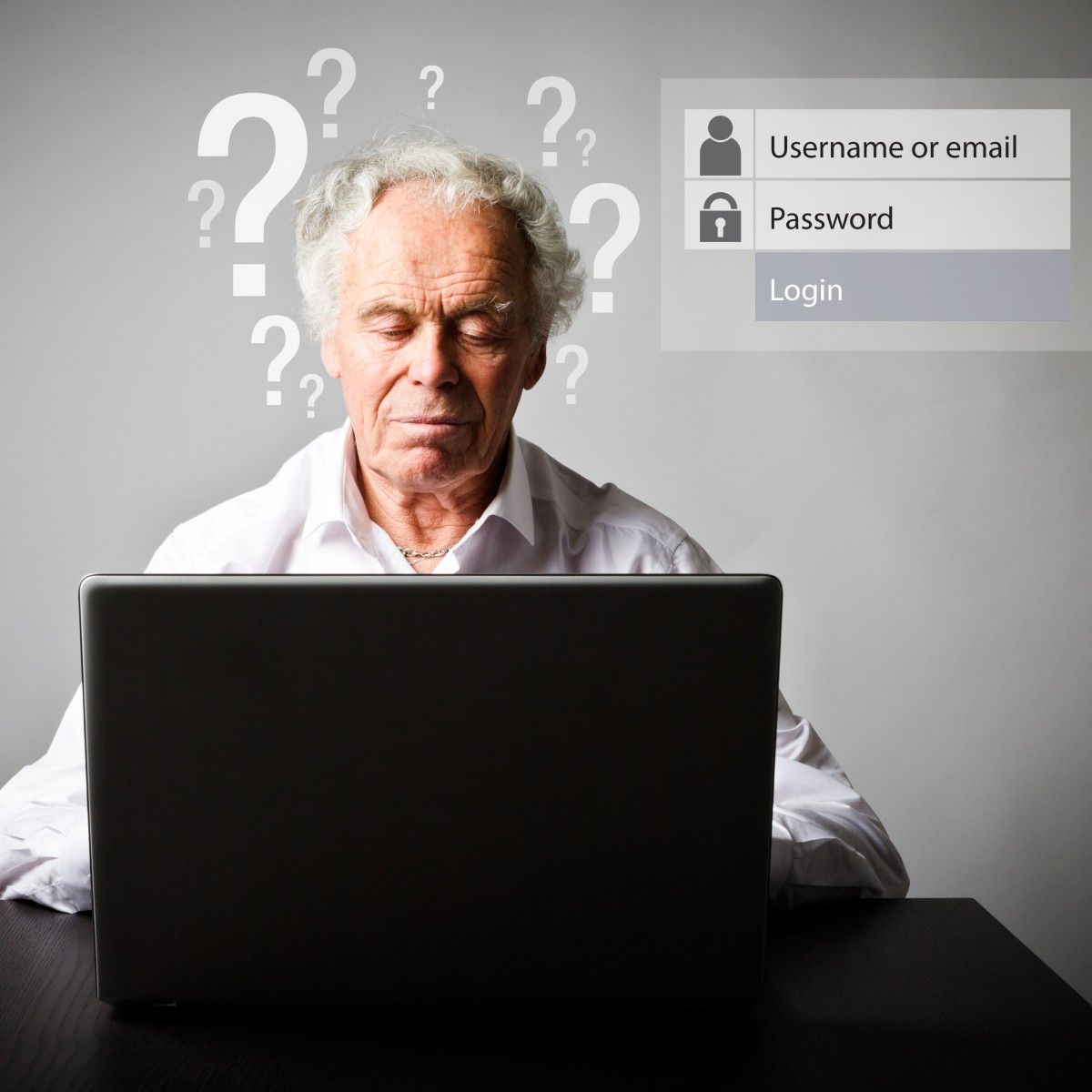An older man sits at a laptop trying to remember his username and password