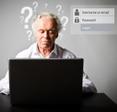 An older man sits at a laptop trying to remember his username and password