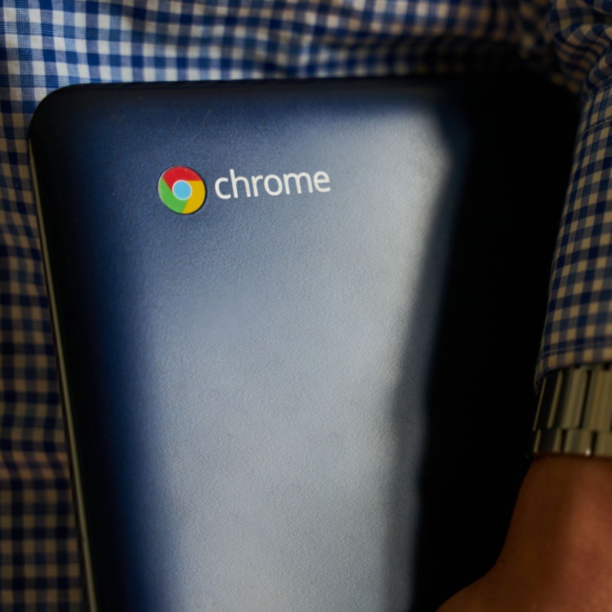 a person carrying a chromebook laptop