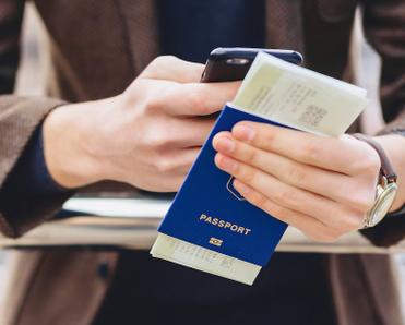 A person holding a passport with a boarding pass stuck inside.