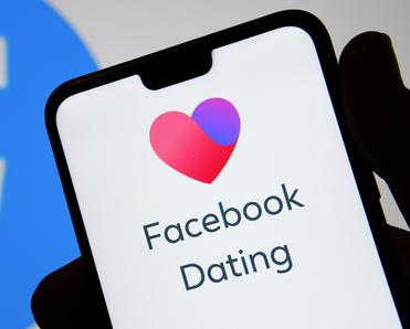 Phone screen with heart and Facebook Dating app