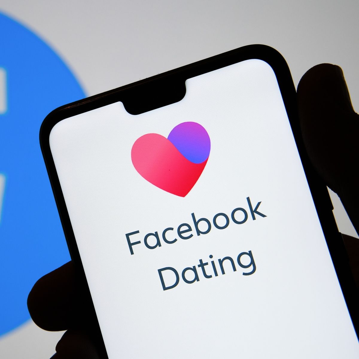 Phone screen with heart and Facebook Dating app