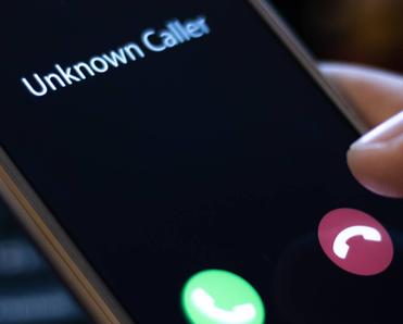 A close-up of a smartphone screen receiving a call from an unknown caller.