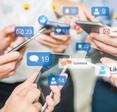 A close up of a group of people&#x27;s hands holding smartphones and messaging each other on social media.