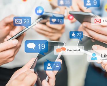 A close up of a group of people&#x27;s hands holding smartphones and messaging each other on social media.