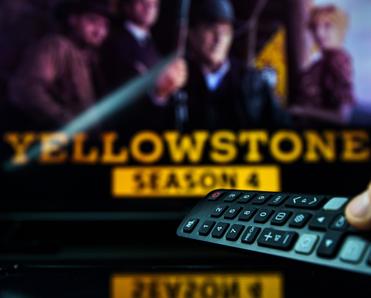 TV background with Yellowstone TV show on and remote control aimed at TV