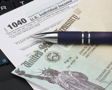 U.S. IRS income tax filing form 1040 with a pen on a keyboard.