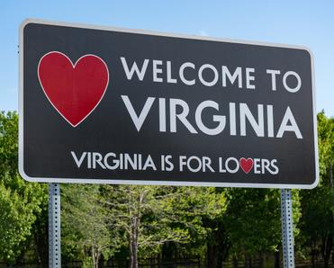A roadside sign that says Welcome to Virginia and Virginia is for lovers with a red heart on the left-hand side.