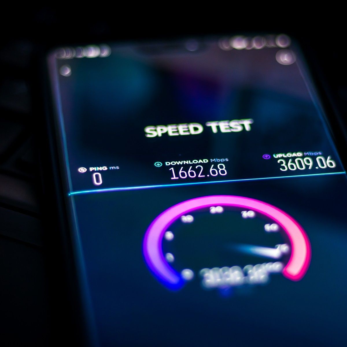 A close-up of a cell phone screen showing an internet speed test result with 0 ping, 1,662 Mbps download speed, and 3,609 Mbps upload speed.