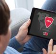 A man holds a tablet that shows a VPN with a red shield logo connecting to a server.