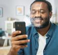 A young bearded Black man holds his cell phone in front of his face with an illustration of the phone&#x27;s camera scanning his face so he can log into his phone using facial recognition
