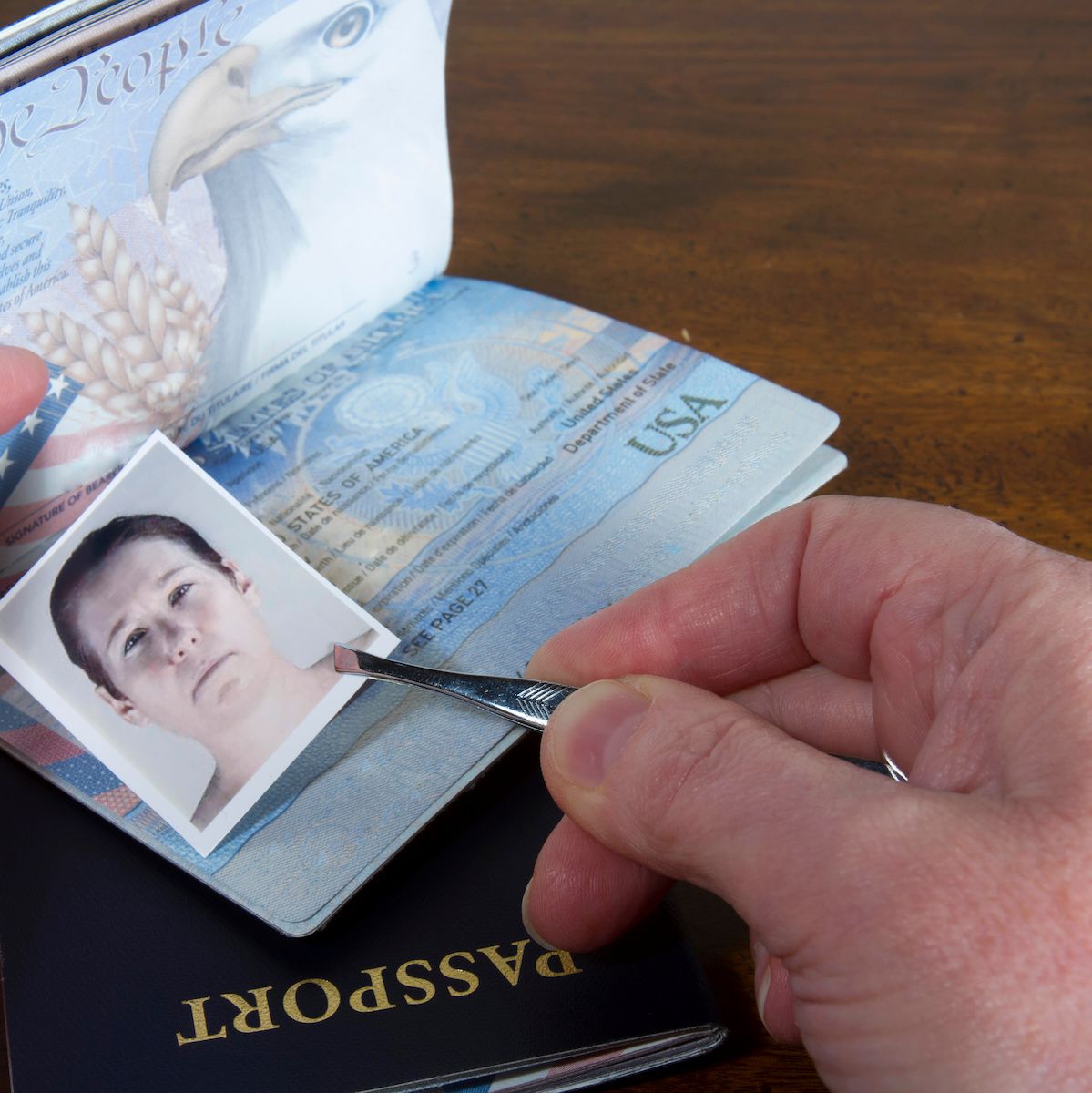 A close-up of a man&#x27;s hands fording a US passport, which can be a type of synthetic identity theft.